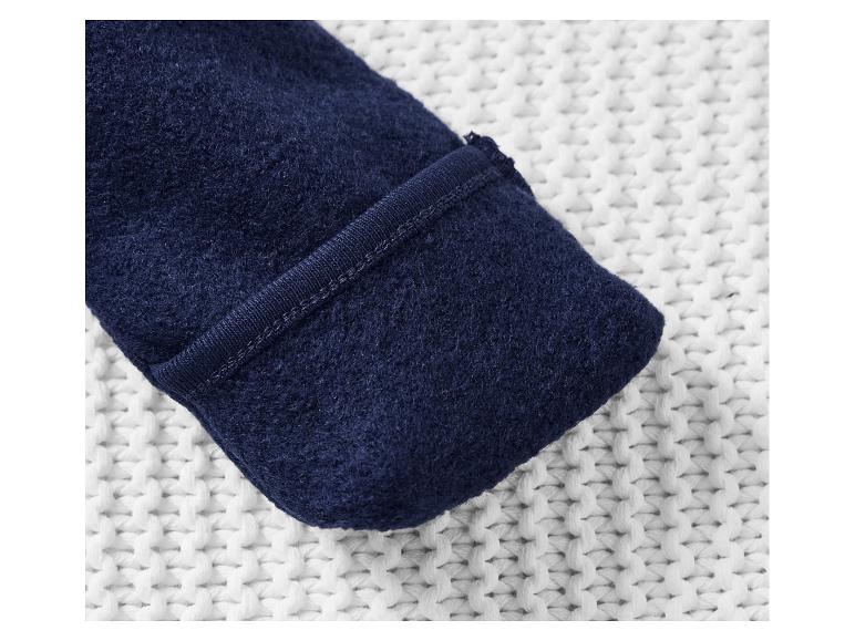 Gros plan sur un tissu doux bleu marine avec une couture visible.