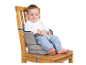 Un bébé assis sur une chaise haute pour bébé sûre et confortable, fixée à une chaise ordinaire.