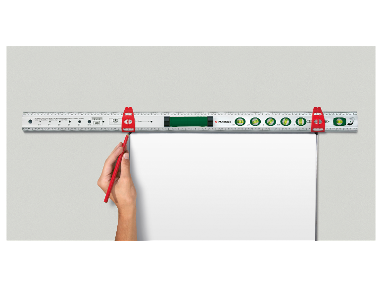 Un niveau à bulle et une règle PARKSIDE utilisés pour tracer sur du papier blanc.
