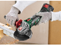 Mains gantées utilisant une meuleuse d'angle pour couper une barre métallique, avec des étincelles.