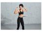 Une femme en tenue de sport portant un bandeau de fitness autour de sa taille.