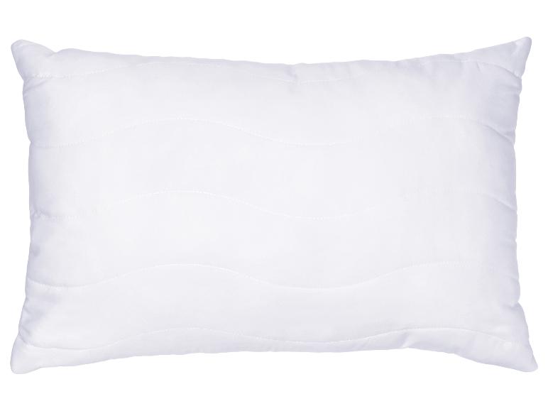 Oreiller blanc avec un motif de couture ondulé