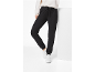 Femme en pantalon de survêtement noir et baskets blanches, posant avec une jambe levée.
