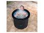 Homme dans un bain de glace portable éclaboussant de l'eau sur une terrasse carrelée.