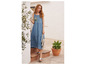 Une femme porte une robe en jean bleu et des sandales Birkenstock.