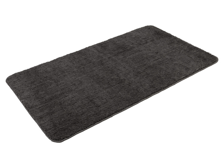 Un tapis de bain gris foncé.