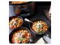 Une mijoteuse Crock-Pot avec trois bols de soupe tomate.