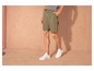 Un homme portant un short vert et des baskets blanches.