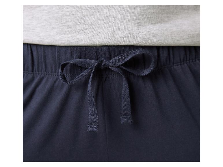 Gros plan d'un pantalon de pyjama bleu marine avec cordon de serrage et un t-shirt gris clair.