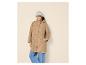 Femme en veste beige, jean et bonnet gris.