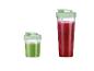 Deux smoothies verts dans des verres avec des couvercles verts.