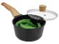 Casserole noire avec manche en bois, couvercle en verre et pois mange-tout