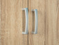 Deux poignées argentées sur une porte d'armoire en bois.
