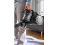 Personne tenant un aspirateur traîneau noir sans sac avec un bac à poussière transparent.