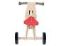 Draisienne en bois avec une selle rouge et des roues noires.