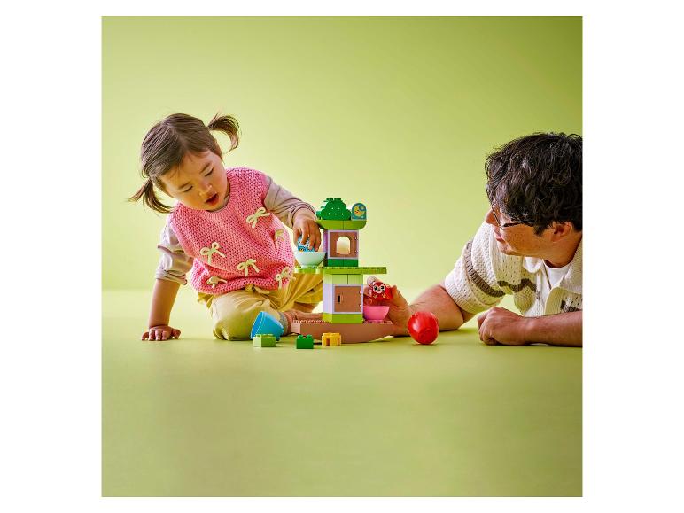 Enfant et adulte jouant avec une cabane dans les arbres LEGO DUPLO.