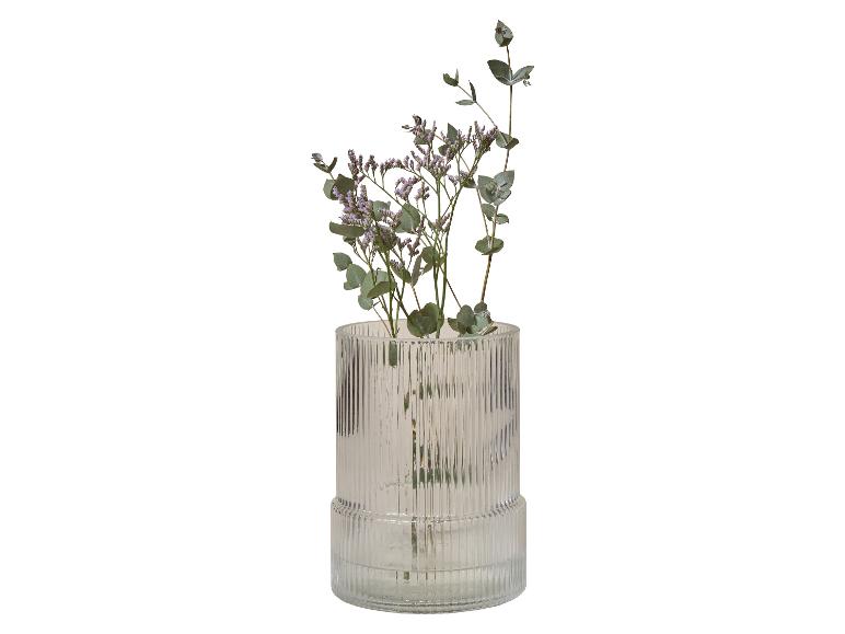 Vase en verre nervuré avec des fleurs violettes et des branches d'eucalyptus