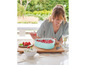 Une femme présente un moule à gâteau en forme de cœur avec des fraises.
