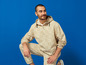 Un homme en veste et pantalon Lidl beige.