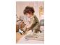 Un petit enfant en adorable pyjama ours se trouve assis sur un tapis de jeu.