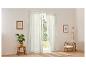 Rideaux en lin clair et fauteuil beige dans un intérieur moderne.