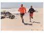 Couple courant sur la plage en vêtements de sport.