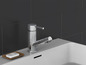 Un robinet chromé sur un lavabo blanc avec un porte-savon.