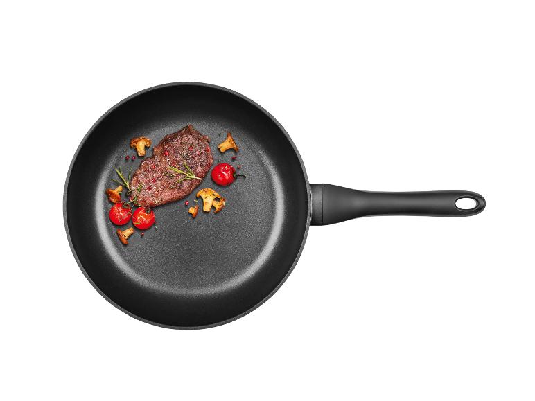 Un steak grillé avec des champignons et des tomates cerises dans une poêle.