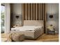 Un lit beige avec un matelas et une table de chevet dans une chambre moderne.