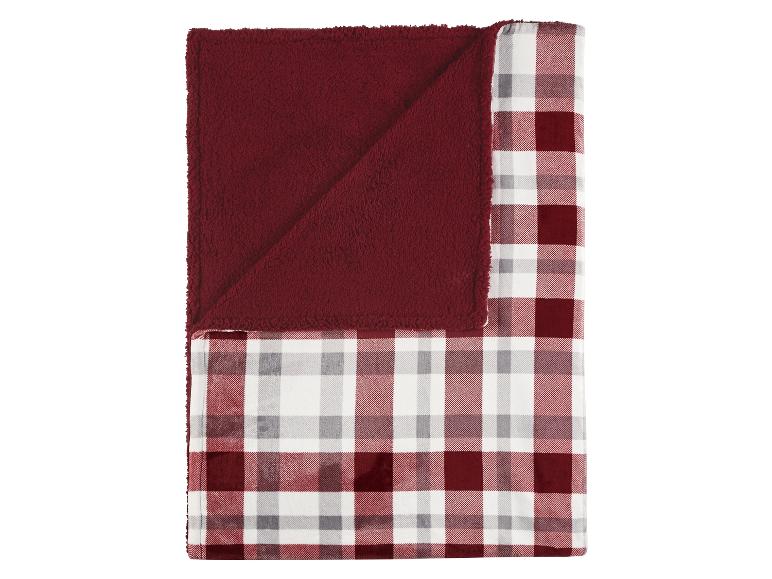 Couverture douce et réversible avec un motif à carreaux rouges et blancs et un côté en peluche rouge.