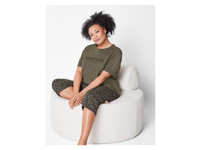 Une femme porte un t-shirt vert olive et un pantalon léopard.