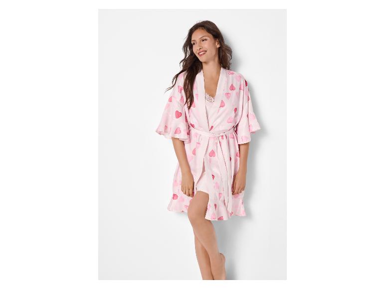 Femme en robe de chambre rose à motifs de cœurs