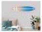 Planche de surf en bois sur un mur au-dessus d'un lit avec des coussins et des plantes.