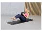 Femme faisant des exercices abdominaux sur un tapis de yoga avec un ballon lesté.