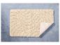Un tapis de bain beige avec une texture ondulée.