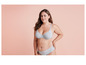 Une femme portant un soutien-gorge et une culotte gris.