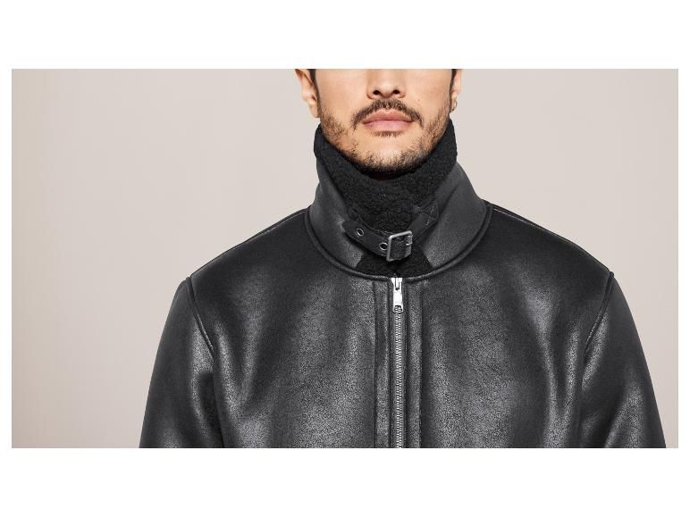 Blouson noir en similicuir avec col et fermeture éclair.