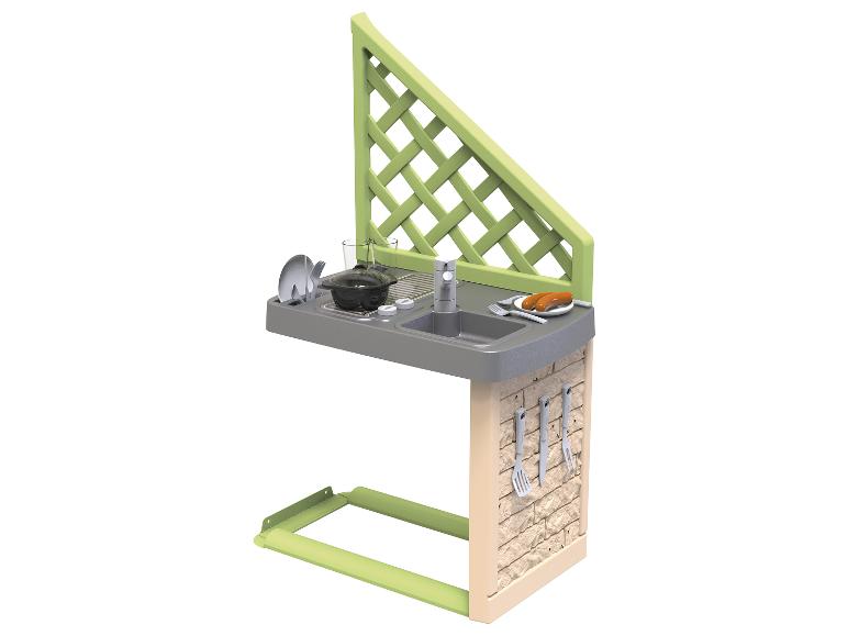 Cuisine de jardin jouet avec évier, plaque de cuisson, ustensiles et saucisses grillées.