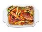 Cuisses de poulet rôties avec des pommes de terre, des carottes et des oignons verts.