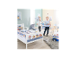 Chambre d'enfant avec lit, coffre à jouets et table sur le thème des chiots.