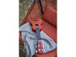 Une ukulélé sur une couverture grise sur une chaise orange.