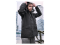 Homme en veste gris foncé à capuche dans un décor urbain.