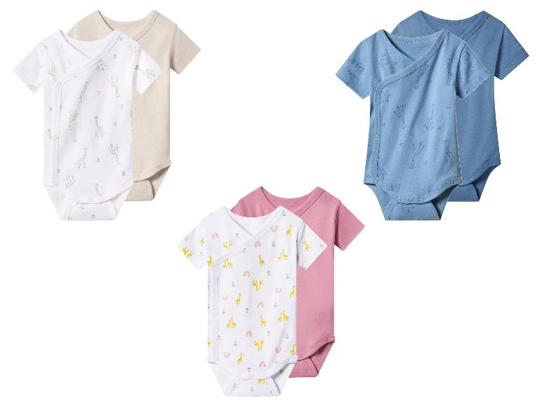 Trois ensembles de bodys pour bébé: blancs avec girafes, bleus avec girafes et blancs avec girafes et arcs-en-ciel.