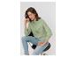 Femme en sweat-shirt vert et jean assise sur une chaise.