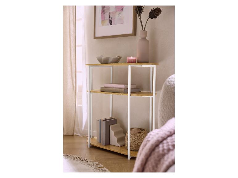 Étagère en bois avec pieds en métal blanc, livres, un vase et une bougie dans une pièce douillette.