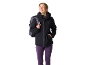 Femme en veste noire avec fermeture éclair violette et pantalon violet, avec sac à dos.