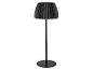 Lampadaire noir avec un abat-jour plissé, émettant une lueur chaude.