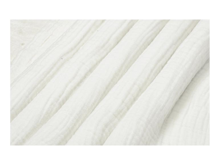 Détail de tissu blanc légèrement froissé avec des plis diagonaux