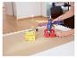 Femme utilise un pistolet à colle LIVARNO® pour coller un jouet en bois sur du papier brun.