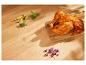 Poulet rôti, légumes et pousses sur planche en bois.